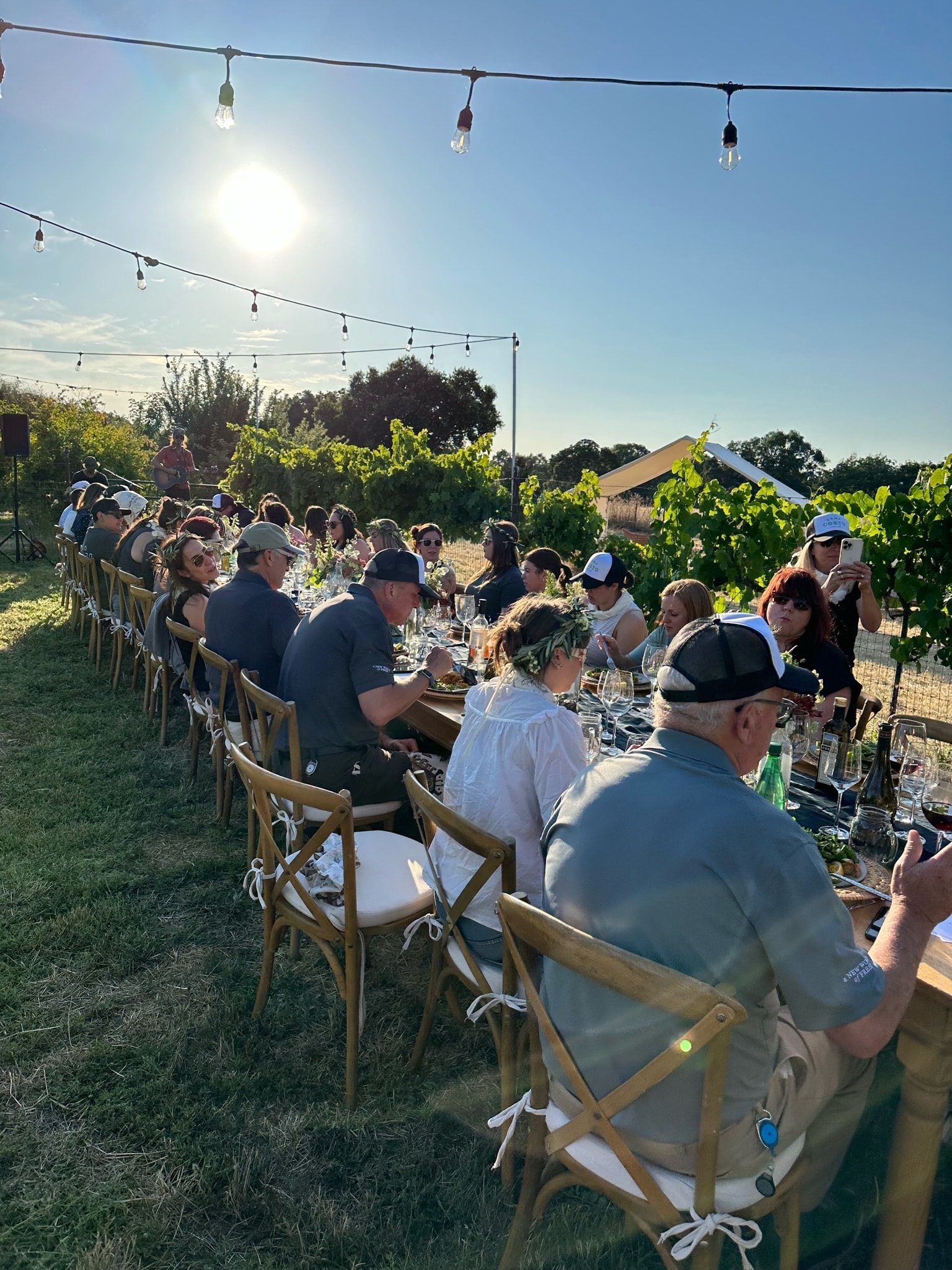 Guests gathered around a long outdoor dinner table at Camp Corto, Lodi CA
